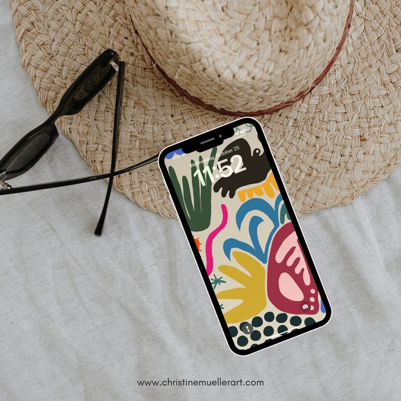 Puede incluir: Una funda de tel&eacute;fono abstracta colorida con un reloj digital que muestra las 11:52. La funda presenta una variedad de formas y colores, incluyendo amarillo, rojo, azul, verde y rosa. El fondo es beige claro.