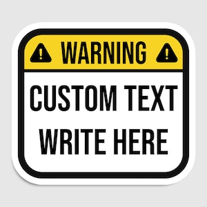 Peut inclure: Un panneau d'avertissement jaune et noir avec un fond blanc. Le panneau comporte deux points d'exclamation et le texte "WARNING" en majuscules. Sous le texte d'avertissement, le texte "CUSTOM TEXT WRITE HERE" en majuscules.