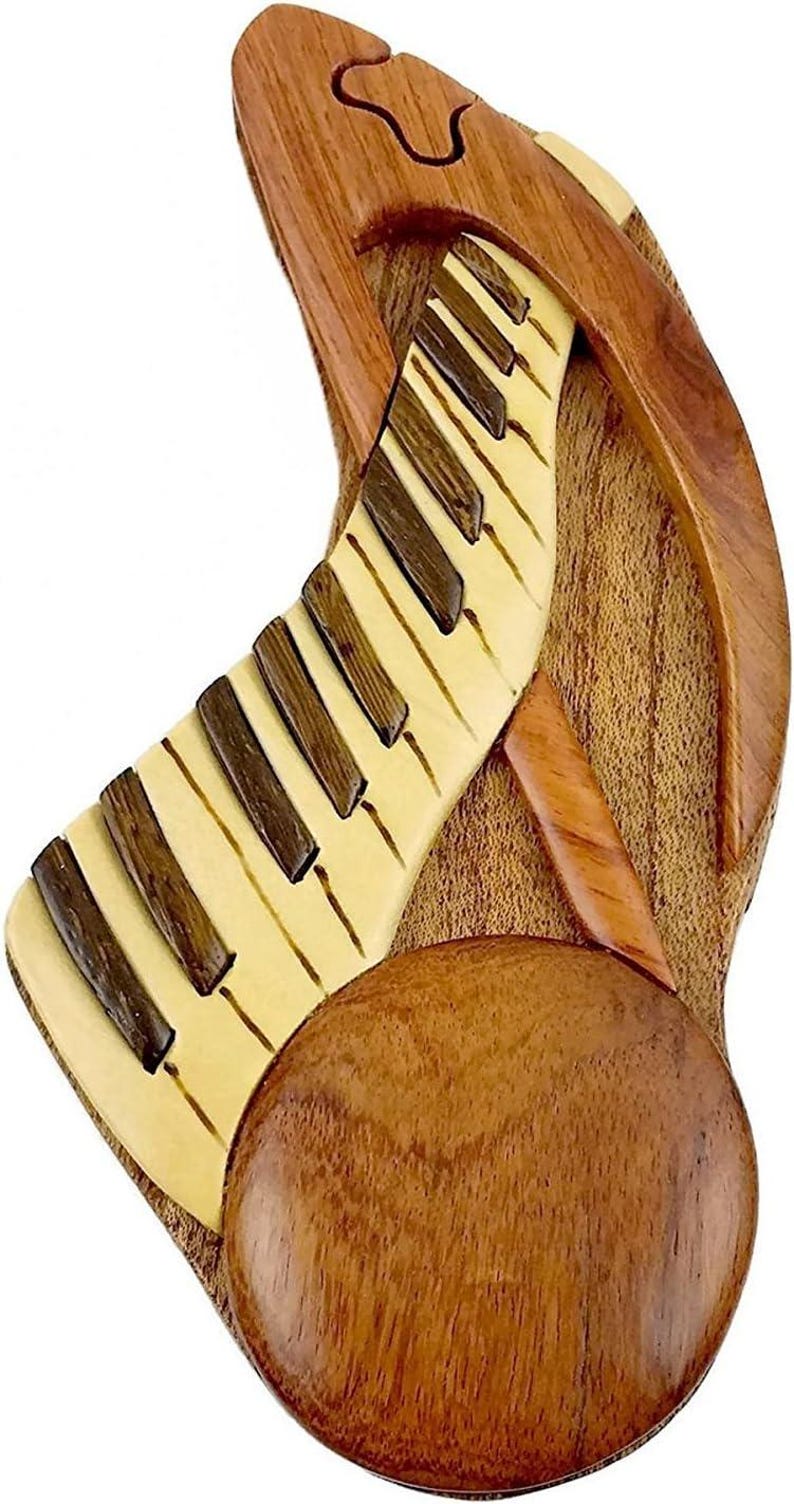 May include: A wooden puzzle box shaped like a piano with a round lid. The piano keys are made of wood and the box is made of a dark brown wood.