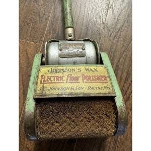 May include: Vintage green and silver electric floor polisher with a brown brush. The polisher has a label that reads "Johnson's Wax Electric Floor Polisher S.C. Johnson & Son - Racine, Wis."