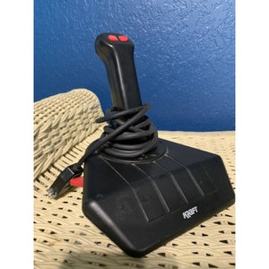 May include: Black joystick with a red button on the top and a black base with the word "KRAFT" printed on it.
