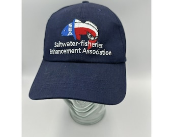 May include: A navy blue baseball cap with an embroidered logo of a fish with the text "Saltwater-fisheries Enhancement Association" and the acronym "SEA" in white.