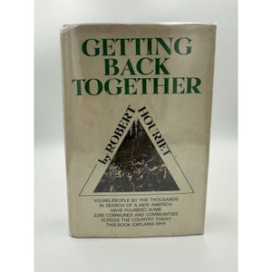 May include: A book cover with a green triangle featuring a group of people in a forest. The title of the book is "Getting Back Together" by Robert Houriet. The text on the cover reads "Young people by the thousands in search of a new America have founded some 2,000 communes and communities across the country today. This book explains why."