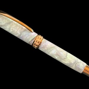 May include: A white ceramic mug with a black handle and the text "But First, Coffee" in a bold, black font. The mug is set against a blurred background, highlighting its clean design.