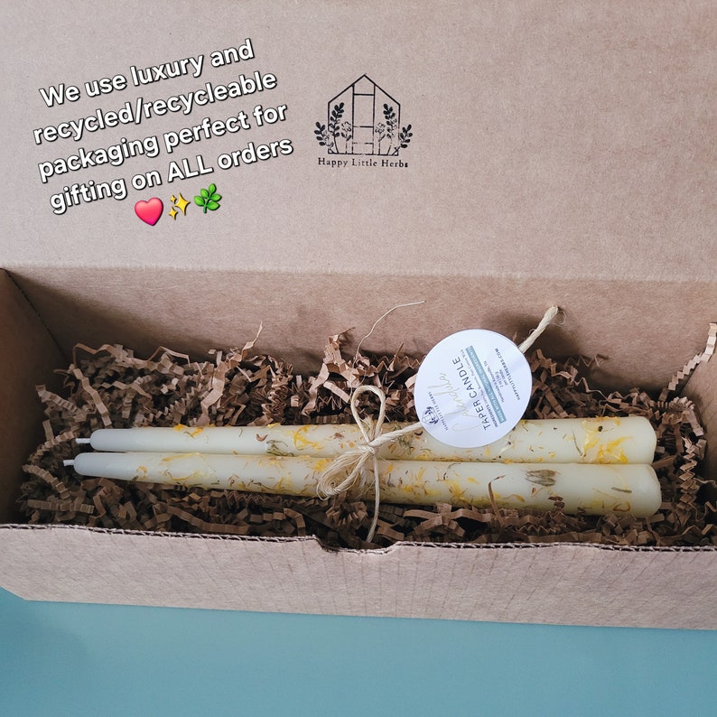 Beautiful handmade beeswax taper candles with hand dipped calendula flowers adorning the outside of the candle. The candles are tied with a twine bow and sat in premium crinkle paper inside a premium shipping box that is recyclable.