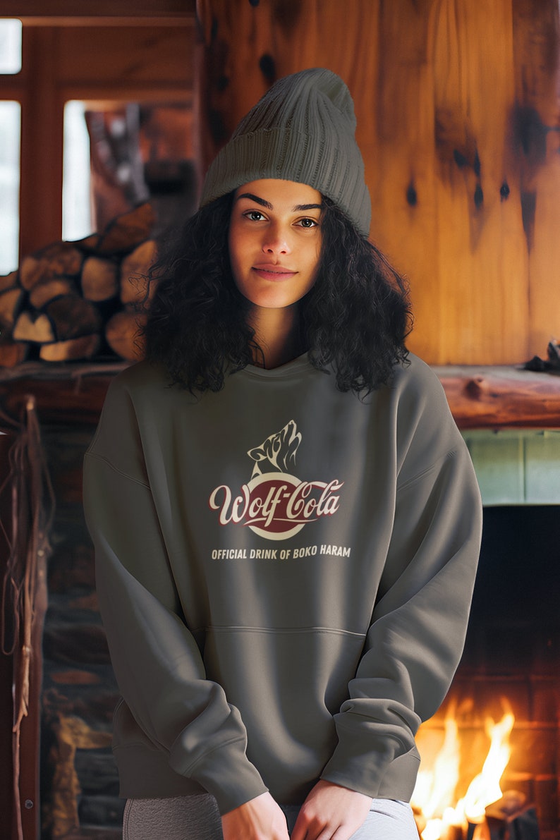May include: A dark gray sweatshirt with a red and white logo that says "Wolf-Cola" and the text "Official Drink of Boko Haram".