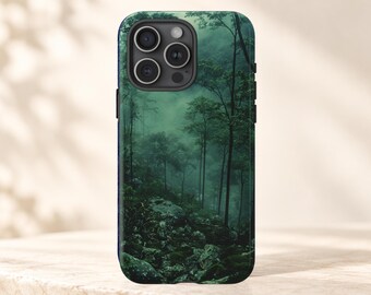 Op de afbeelding: Een smartphonehoesje met een hoge resolutie print van een dicht, mistig boslandschap. Het ontwerp toont hoge, slanke bomen die oprijzen uit een rotsachtige, met mos bedekte bodem, uitgevoerd in diepe smaragd- en bosgroene tinten.