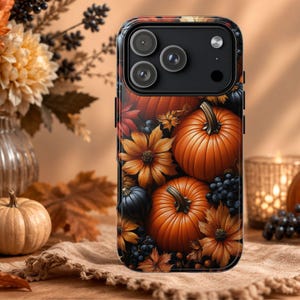 May include: A smartphone case featuring a vibrant autumn-themed print of orange pumpkins, dark blue berries, and golden-brown flowers. The design covers the entire back of the case, including the area around the triple-lens camera module.