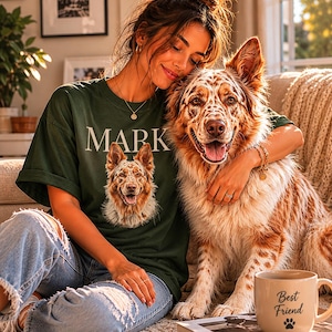 May include: A dark green t-shirt featuring the text MARK above a graphic of a speckled brown and white dog. The shirt is paired with light blue distressed denim jeans. A beige ceramic mug with the text Best Friend and a paw print is visible.