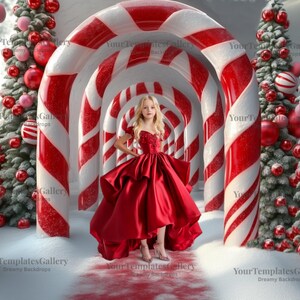 Peut inclure: Une jeune personne en robe de satin rouge se tient dans une scène de Noël fantaisiste. La toile de fond présente des arches de cannes en sucre, un sol enneigé et des arbres de Noël décorés. L'ambiance est festive et onirique.