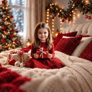 Puede incluir: Un niño con cabello castaño largo y vestido rojo de manga larga, sentado en una cama con una manta de punto color crema y cojines rojos, sosteniendo una pequeña caja de regalo roja con cinta blanca, cerca de un árbol de Navidad.