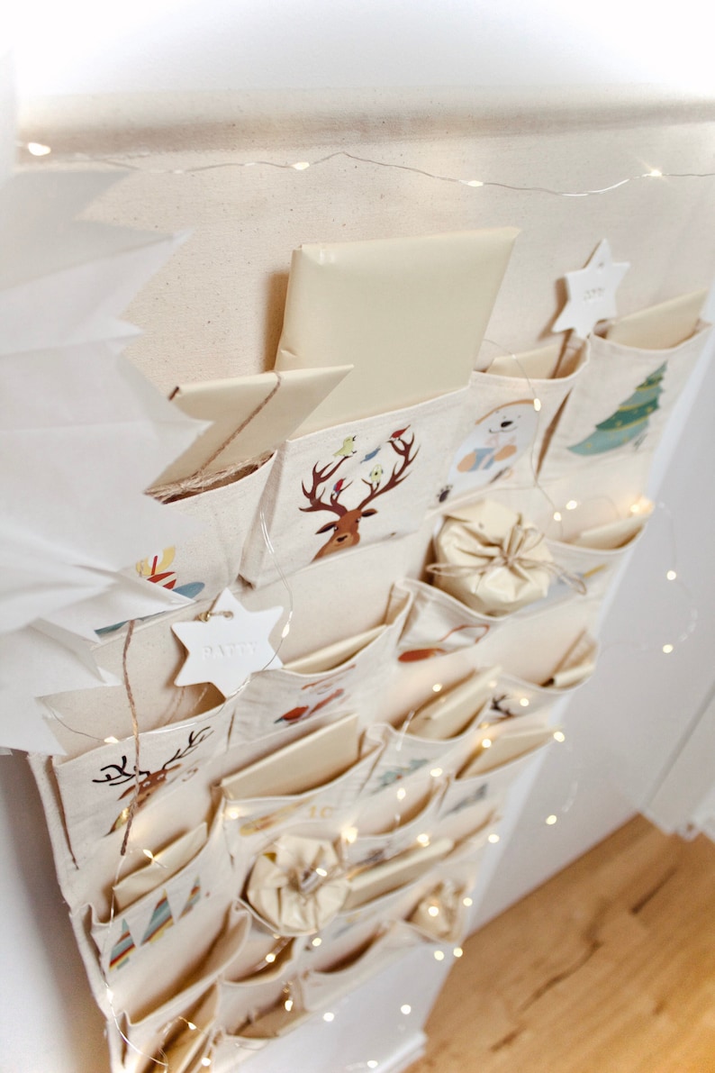 Beiger Adventskalender Leinen-Stoff zum Befüllen, für Kinder und Erwachsene, zum an die Wand hängen mit Kordel und Holzstange, Ziermotive, Rentier, Weihnachtsmann, Weihnachten, Dekoration für Geschenke, beige, rot, grün, braun, blau