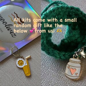 May include: A close-up of two small charms. One charm is a yellow glass of juice with a straw and a white flower. The other charm is a white jar with a pink heart and two smaller pink hearts. The text on the image reads "All kits come with a small random gift like the below from us!"