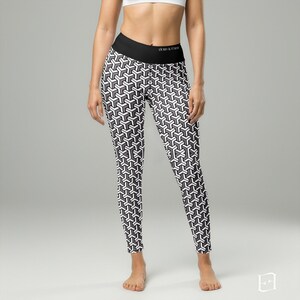 May include: Black and white geometric pattern leggings with a black waistband. The leggings feature a repeating 3D cube design. The waistband has the text "Hood & Finn".