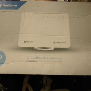May include: A white box with the NetComm logo and the text "CloudMesh Gateway NF18MESH - THE ULTIMATE WIFI FIXER" on it.