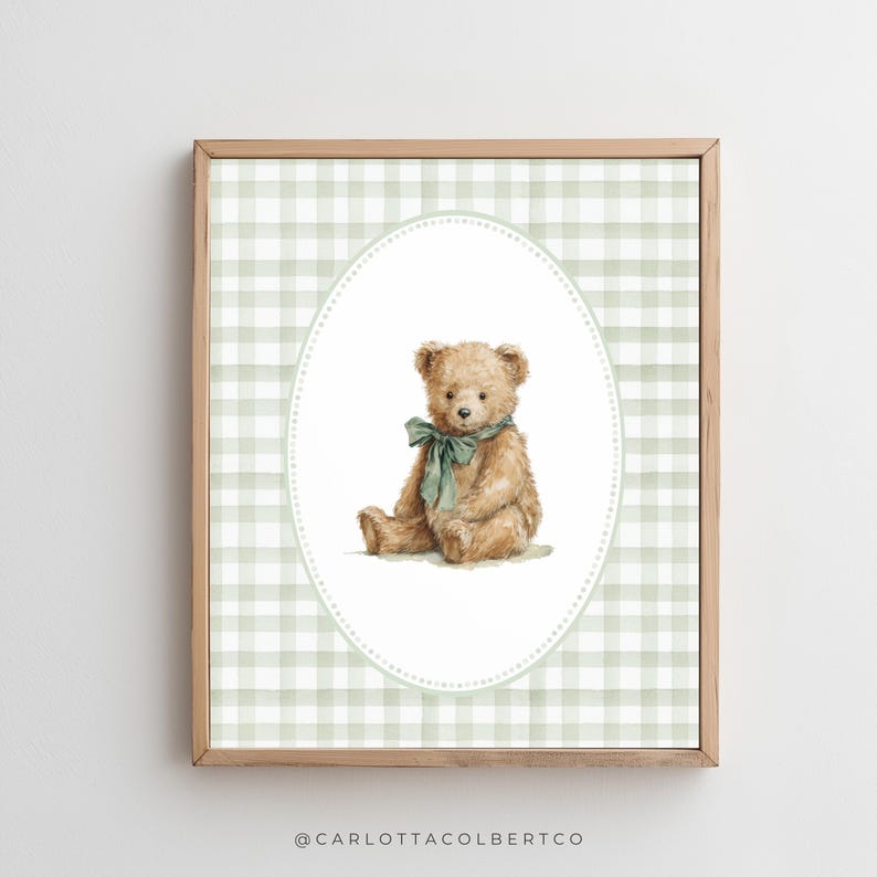 May include: A framed print featuring a watercolor illustration of a teddy bear. The bear is light brown with a green bow, set against a green and white gingham background within an oval frame. The frame is made of wood.