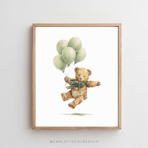 Pu&ograve; includere: Una stampa ad acquerello incorniciata raffigura un orsacchiotto marrone che fluttua con palloncini verdi. L'orso indossa un fiocco verde e sembra essere a mezz'aria. L'opera &egrave; ambientata su uno sfondo bianco, con una cornice in legno marrone chiaro.