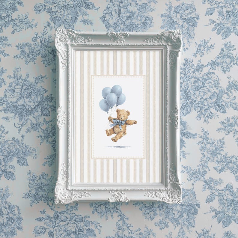 K&ouml;nnte beinhalten: Ein gerahmter Druck mit einer Aquarellillustration eines Teddyb&auml;ren, der blaue Luftballons h&auml;lt. Der B&auml;r hat eine blaue Schleife und befindet sich vor einem gestreiften Hintergrund in einem wei&szlig;en, verzierten Rahmen. Der Hintergrund ist eine blaue Blumentapete.