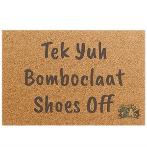 Pode incluir: Um capacho retangular com uma superf&iacute;cie texturizada castanho-clara. O tapete apresenta o texto "Tek Yuh Bomboclaat Shoes Off" em letras castanho-escuras. As palavras s&atilde;o empilhadas verticalmente. Um logotipo no canto inferior direito.