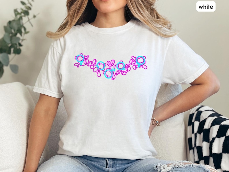 Puede incluir: Una camiseta blanca con un dise&ntilde;o gr&aacute;fico rosa y azul de una serie de c&iacute;rculos conectados.