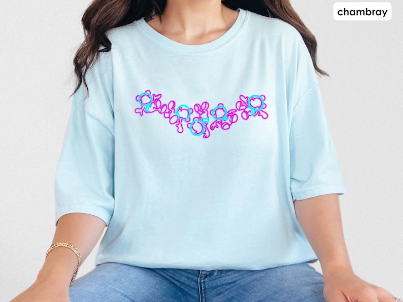 Puede incluir: Una camiseta azul claro con un dise&ntilde;o gr&aacute;fico rosa y azul de una serie de c&iacute;rculos conectados. La camiseta est&aacute; hecha de una tela suave y c&oacute;moda.