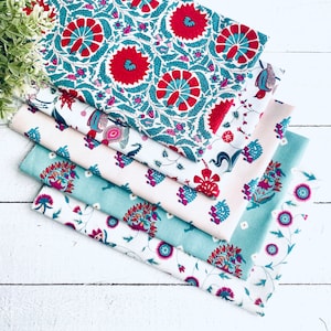 May include: A stack of five fabric squares featuring a floral pattern in shades of pink, blue, and white. The fabric has a traditional Indian design with paisley and floral motifs.