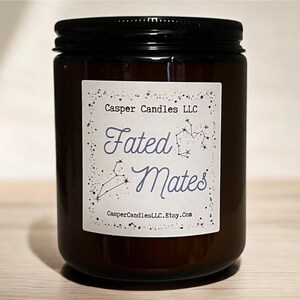 Peut inclure: Un bocal en verre brun contenant une bougie avec une étiquette blanche sur laquelle est inscrit "Casper Candles LLC Fated Mates CasperCandlesLLC.Etsy.com". L'étiquette présente un motif de constellation avec un contour violet.