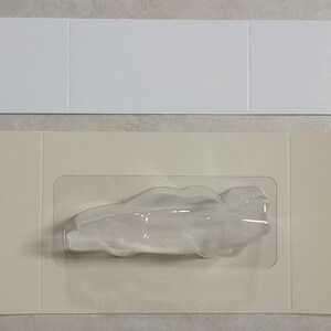 Puede incluir: Un molde de pl&aacute;stico transparente con forma de pez, sobre un fondo blanco. El molde est&aacute; dise&ntilde;ado para hacer chocolate u otras golosinas comestibles.