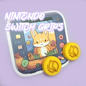 May include: Two yellow Nintendo Switch controller grips with a lightning bolt design. The grips are on top of a sticker of a Nintendo Switch console with a cartoon fox on the screen. The sticker says "Nintendo Switch Grips".
