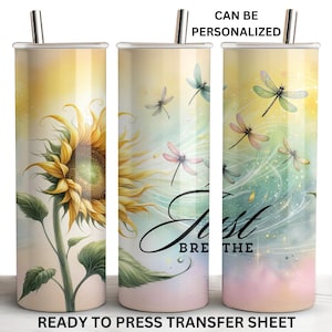 May include: A tall, cylindrical tumbler with a sunflower and dragonfly design. The tumbler features a yellow and green sunflower, dragonflies, and the words "Just Breathe." The tumbler has a silver lid and straw. The text "CAN BE PERSONALIZED" and "READY TO PRESS TRANSFER SHEET" are also visible.