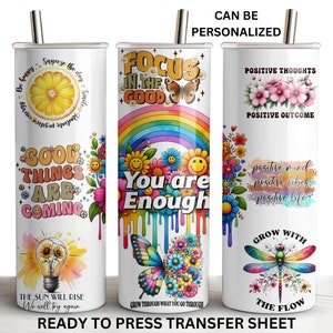May include: Three sublimation tumblers with different designs. The first tumbler has a lemon design with the text "Good things are coming". The second tumbler has a rainbow and butterfly design with the text "Focus in the good, you are enough". The third tumbler has a dragonfly design with the text "Positive thoughts, positive outcome, positive mind, positive vibes, positive life, grow with the flow".
