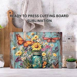 May include: Rectangular cutting board with a floral and butterfly design. The image features a blue mason jar filled with yellow sunflowers and other colorful flowers. Two orange butterflies are also present. The text "READY TO PRESS CUTTING BOARD SUBMLIMATION" is at the top.