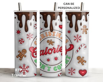 May include: A white tumbler with a stainless steel straw, featuring a design of dripping chocolate, gingerbread men, candy canes, snowflakes, and the text "Christmas Calories Don't Count". The tumbler is a perfect gift for the holiday season.
