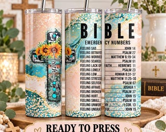 May include: Three cylindrical tumblers with metal straws featuring a peach and teal marble background. One tumbler displays a cross with sunflowers and the word faith. Two tumblers feature the text BIBLE EMERGENCY NUMBERS with a list of feelings and corresponding scripture references.