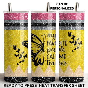 May include: A yellow glitter tumbler with a black butterfly and the text "my favorite people call me teacher". The tumbler has a pink glitter top and black and silver glitter stripes.
