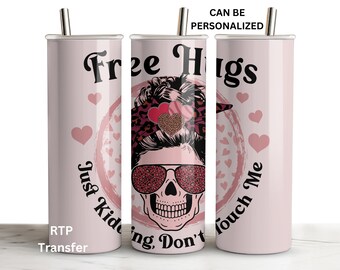 May include: A pink stainless steel tumbler with a skull design and the text "Free Hugs Just Kidding, Don't Touch Me". The skull is wearing sunglasses with a leopard print design and has a bun in its hair. The tumbler is surrounded by pink hearts.
