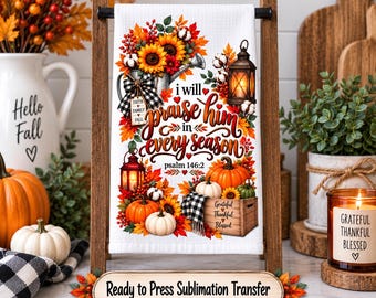May include: A white kitchen towel featuring a colourful autumn design with sunflowers, pumpkins, lanterns, and fall foliage. The text reads, I will praise him in every season, psalm 146:2, and Grateful Thankful Blessed. A wooden sign below reads Ready to Press Sublimation Transfer.