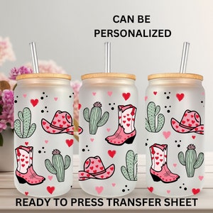 May include: Three frosted glass tumblers with bamboo lids and straws, featuring a pink and green cactus, cowboy boot, and hat design with hearts. The tumblers are ready to press transfer sheets, meaning they can be personalized with a design.