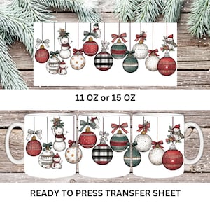 May include: White ceramic mugs with a festive Christmas ornament design. The ornaments include red, green, and black plaid balls, snowmen, and decorative bows. The text "11 OZ or 15 OZ" and "READY TO PRESS TRANSFER SHEET" are also visible.
