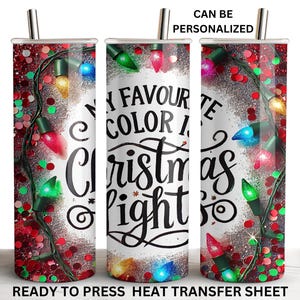 May include: A tumbler with a festive design featuring colorful Christmas lights and the text "MY FAVOURITE COLOR IS Christmas lights". The tumbler has a silver straw and is decorated with red glitter.