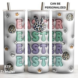 May include: White stainless steel tumbler with a colorful Easter design. The tumbler features the word "Easter" repeated four times in different colors and styles. It also has a bunny and leopard print designs. The tumbler is personalized with the text "Can be personalized".