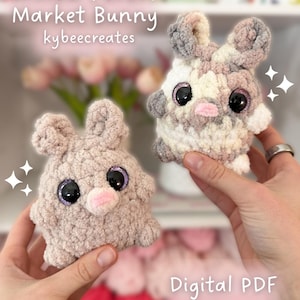 May include: Two handmade crochet bunny toys in the image. One is a solid light brown color, and the other is a mix of white, gray, and pink. Both have large, sparkly black eyes and pink noses. The text "Willow Forest Market Bunny" and "Digital PDF Pattern Only" are visible.