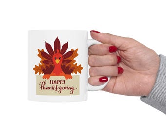 May include: White ceramic mug featuring a cartoon turkey design with fall-colored leaves and the text "Happy Thanksgiving". The turkey is red and orange, with a yellow beak. The mug has a white handle.