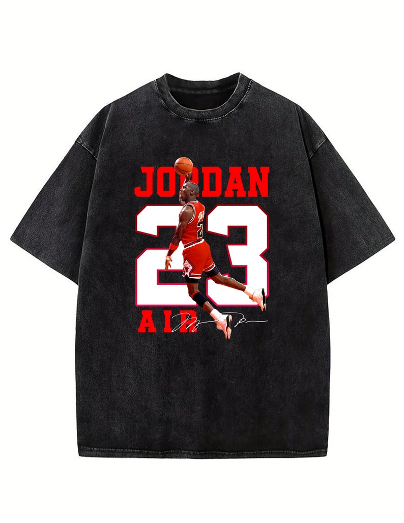 Peut inclure: T-shirt noir &agrave; l'aspect vintage avec un motif rouge et blanc de Michael Jordan portant un maillot de basket-ball avec le num&eacute;ro 23 et le mot "JORDAN" au-dessus et "AIR" en dessous.