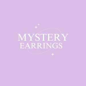 May include: A light purple background with the words "MYSTERY EARRINGS" in white, stylized font. The text is surrounded by a white oval and small starburst graphics.