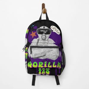 May include: Black backpack featuring a white gorilla wearing VR goggles with the text "GORILLA TAG" in neon green and yellow. A purple background with a star and the words "Let's Go!" in a speech bubble.
