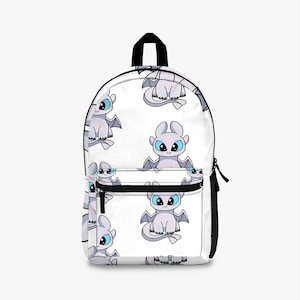 May include: White backpack featuring a repeating pattern of a cartoon dragon with blue eyes and gray wings. The backpack has a black zipper, a black top handle, and black shoulder straps. The design is suitable for school or travel.