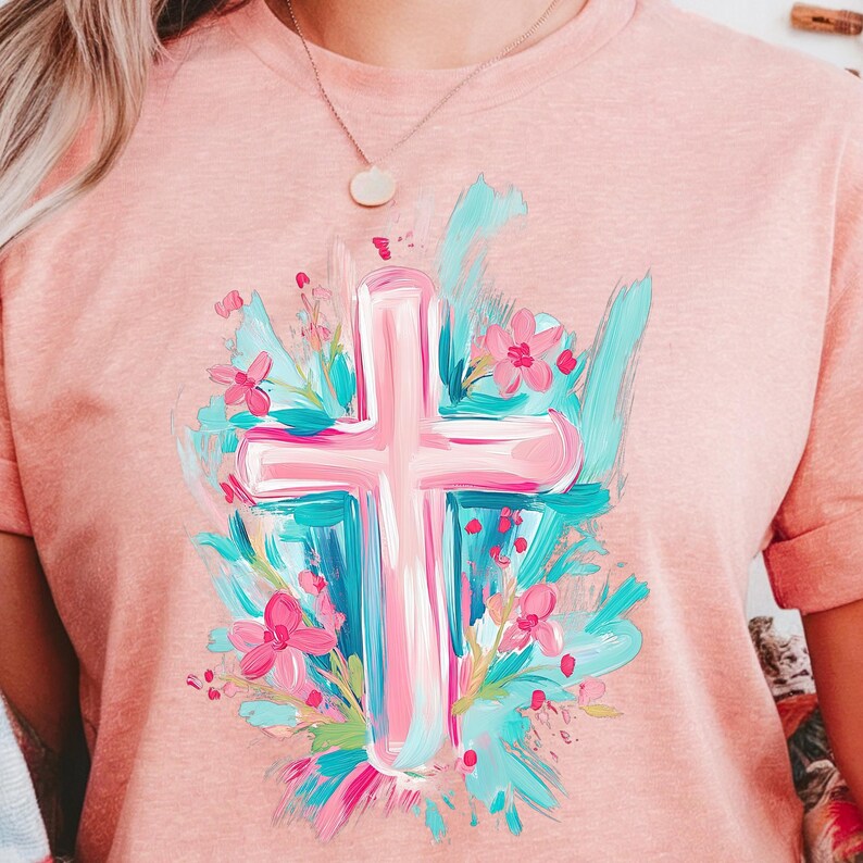May include: A pink cross with a floral design in shades of pink, blue and green. The cross is painted in a brushstroke style and is surrounded by flowers and leaves.