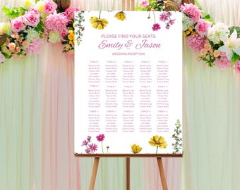 May include: A white wedding seating chart with pink and yellow floral accents. The chart is titled "Please find your seats Emily & Jason Wedding Reception" and lists the names of guests assigned to each table.
