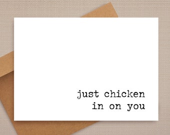 May include: A white card with the text "just chicken in on you" printed in black typewriter font.